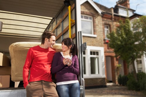 Removalists carrying furniture through a residential property in Holland Park